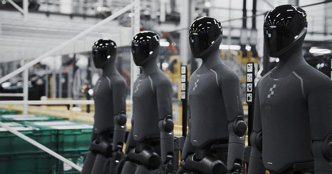 A row of Figure humanoids on a factory aisle.