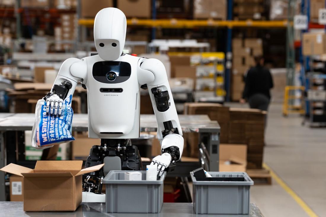 Apollo at a packing bench in a warehouse. Where: Warehouse or 3PL setting (site not named)