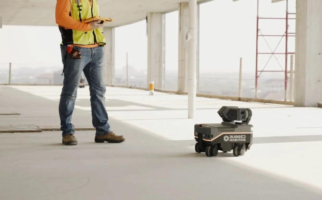 Rugged layout robot with an operator on a slab.