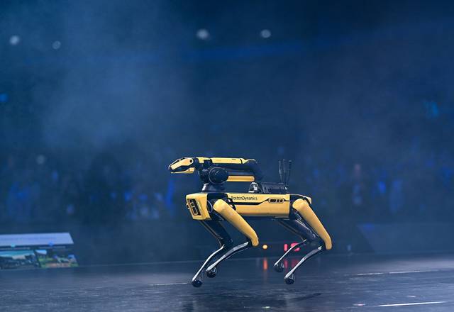 Spot with a manipulator arm on stage.
